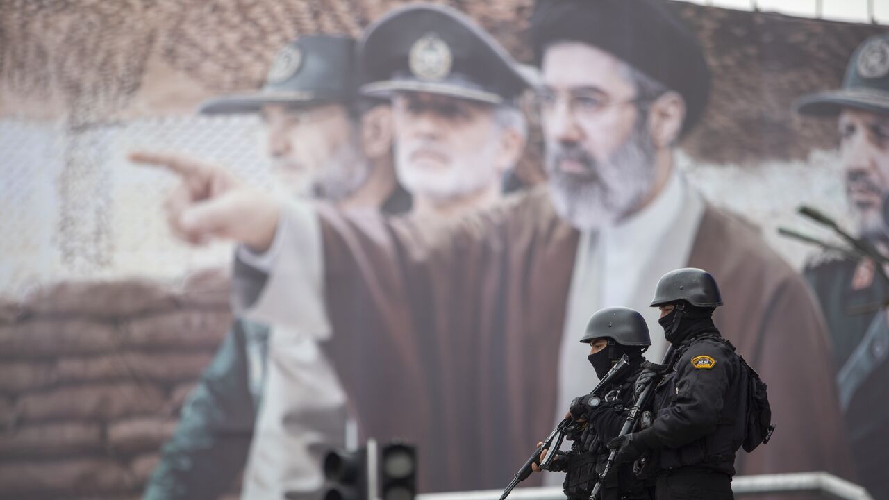  A billboard shows a graphic depicting Iranian Supreme Leader Ayatollah Mojtaba Khamenei with military commanders, as people attend the annual anti-Israeli Quds Day on March 13, 2026, in Tehran, Iran. 
