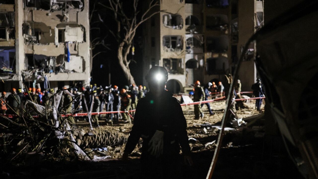 Rescuers at the site of an Iranian missile hit in southern Israel's Arad
