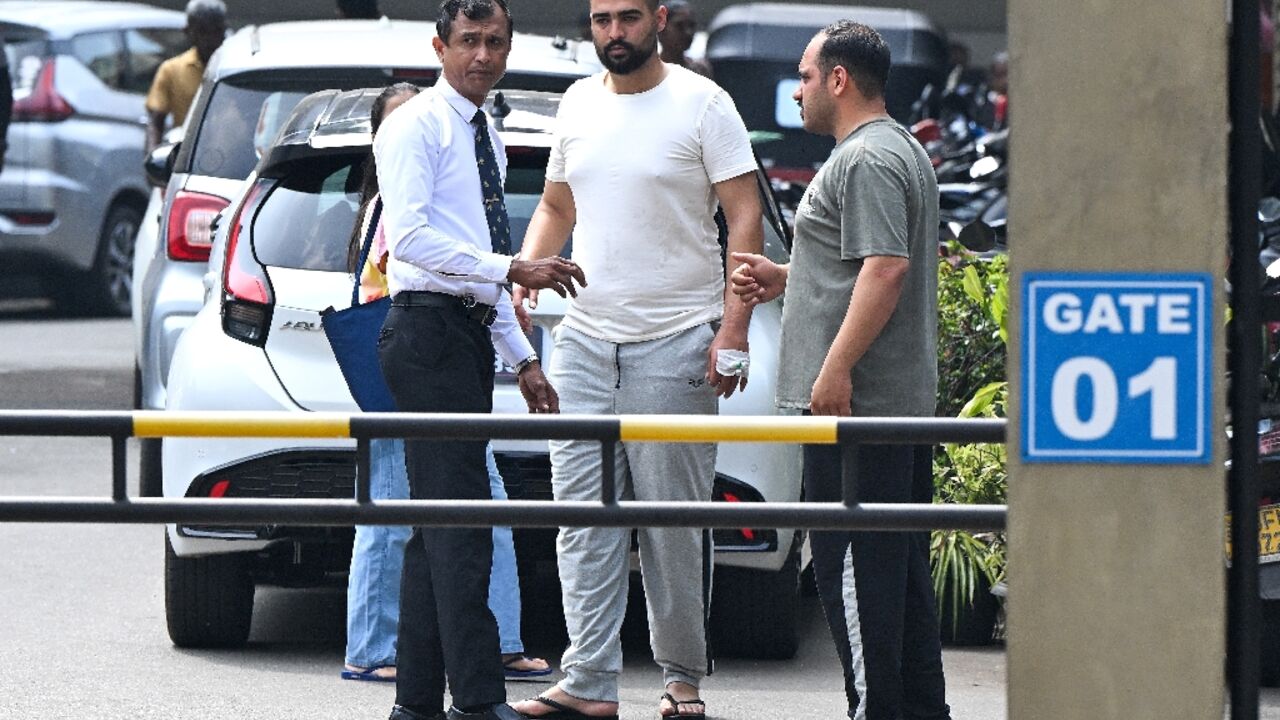 Iranian sailors talk to a hospital staffer at the Karapitiya hospital in the southern city of Galle on March 5