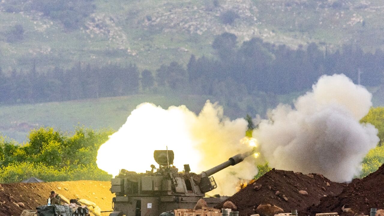An Israeli self-propelled howitzer artillery gun fires rounds toward southern Lebanon