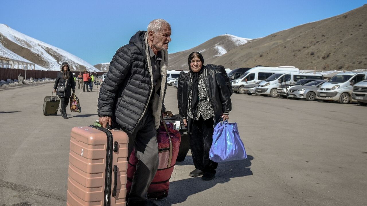 People arrive with bags through the Razi-Kapikoy border crossing 