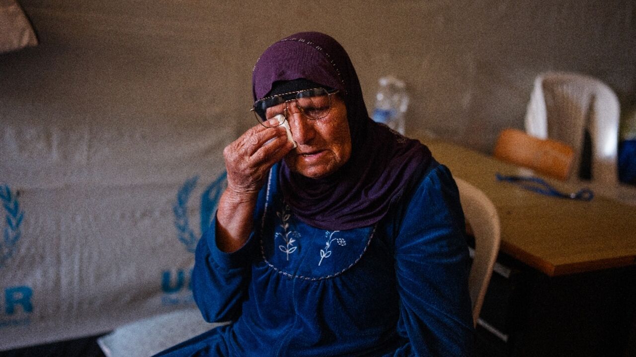 An elderly displaced woman sits in her room at a school being used as a shelter for displaced people in the southern Lebanese city of Tyre 