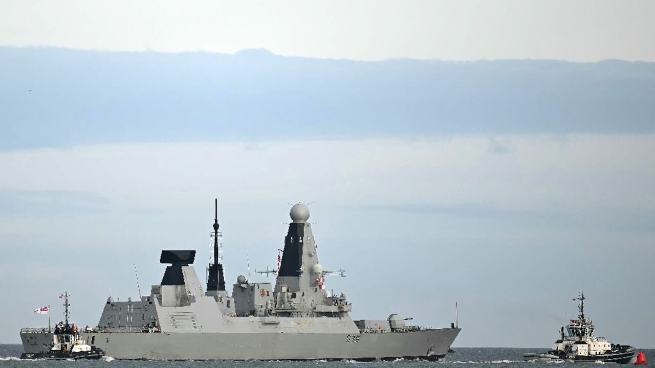 The HMS Dragon is guided by tugboats as it departs Portsmouth, on the south coast of England