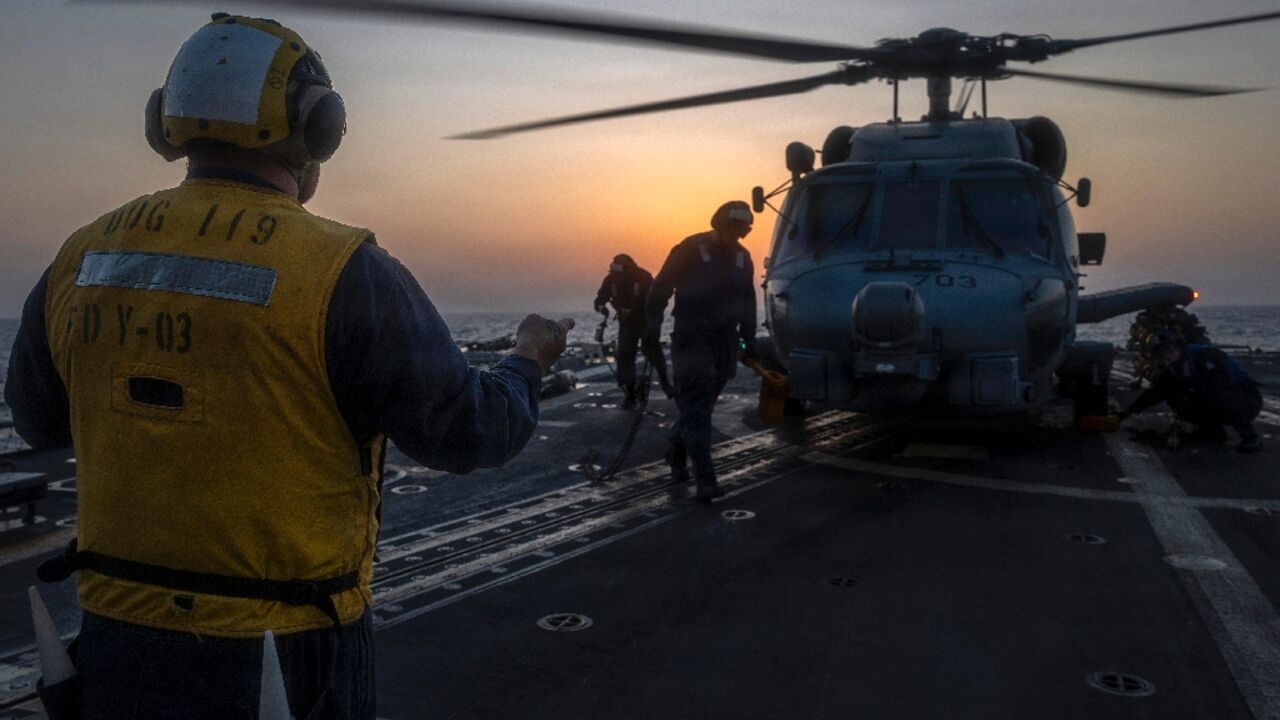 A photo released by US Central Command shows a sailor directing a helicopter aboard the guided missile destroyer USS Delbert D. Black on March 7, 2026