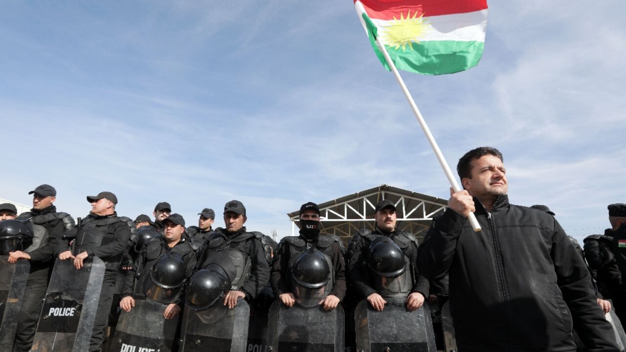 A protester holds a Kurdish flag at a demonstration outside the United Nations office in Arbil, the capital of Iraq's northern autonomous Kurdish region, in January 2024