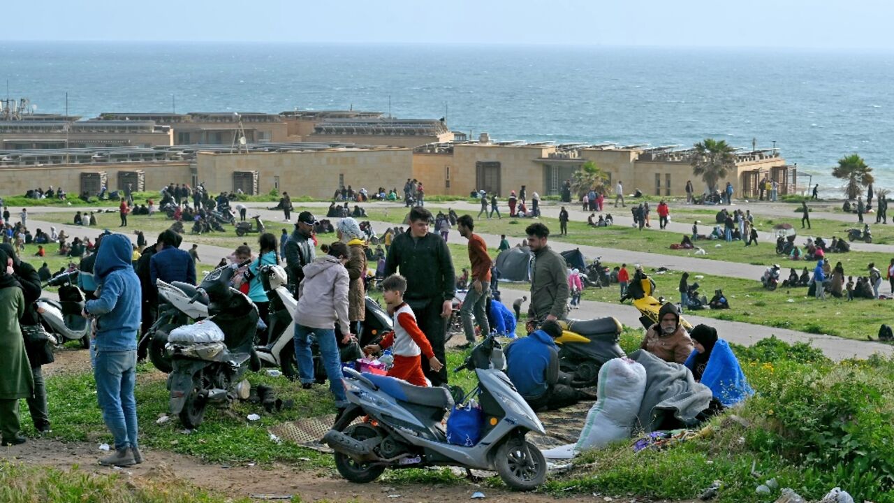 People who fled Beirut's southern suburbs after the latest Israeli bombing warning take refuge by a beach