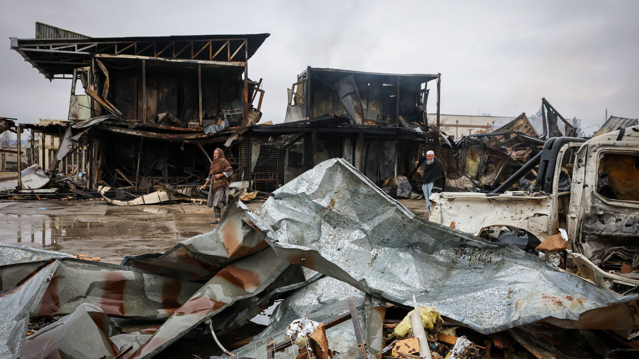 FILE PHOTO: Afghan men walk next to debris lying at the site of a drug rehabilitation center destroyed in what the Taliban said was a Pakistani air strike in Kabul, Afghanistan, March 18, 2026. REUTERS/Sayed Hassib/ File Photo