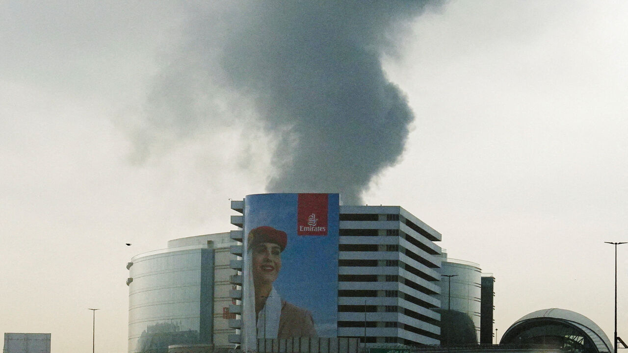 FILE PHOTO: Smoke rising from an area near the Dubai International Airport is seen through the windshield of a vehicle, after a drone attack hit a fuel tank, according to Dubai authorities, amid the U.S.-Israel conflict with Iran, in Dubai, United Arab Emirates, March 16, 2026, REUTERS/Stringer/File Photo