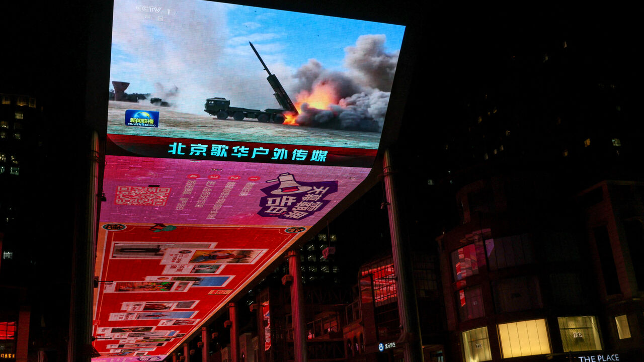 FILE PHOTO: A giant screen shows a news report on China's "Justice Mission 2025" military drills around Taiwan, in Beijing, China December 30, 2025. REUTERS/Tingshu Wang/File Photo