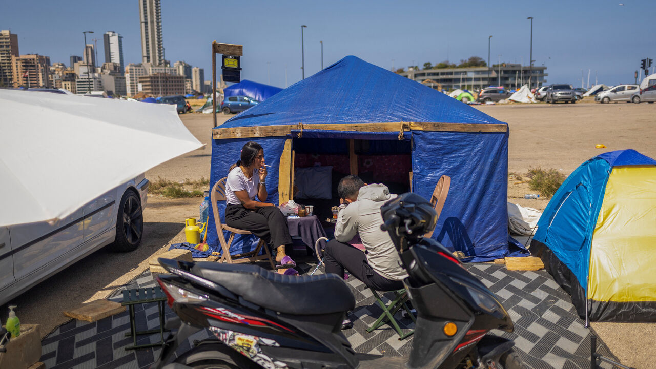A displaced family who fled their home following Israeli evacuation orders sits outside their tent at a makeshift encampment in Beirut, Lebanon, April 10, 2026. REUTERS/Adnan Abidi