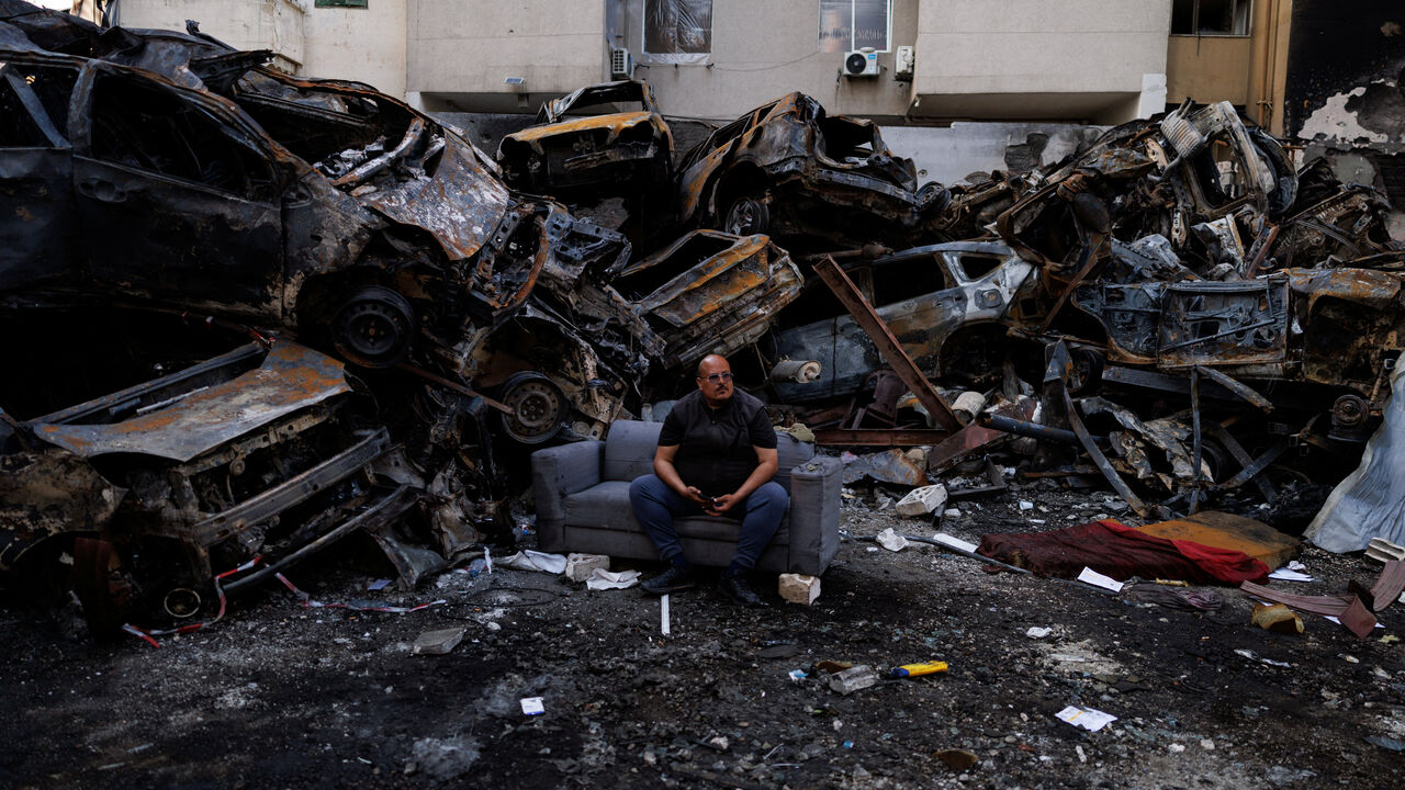 Mohamed El Junayd, 43, who said he survived the Israeli strike, sits beside piled damaged cars at the site of an Israeli strike carried out on April 8, at Corniche al-Mazraa in Beirut, Lebanon April 13, 2026. REUTERS/Zohra Bensemra