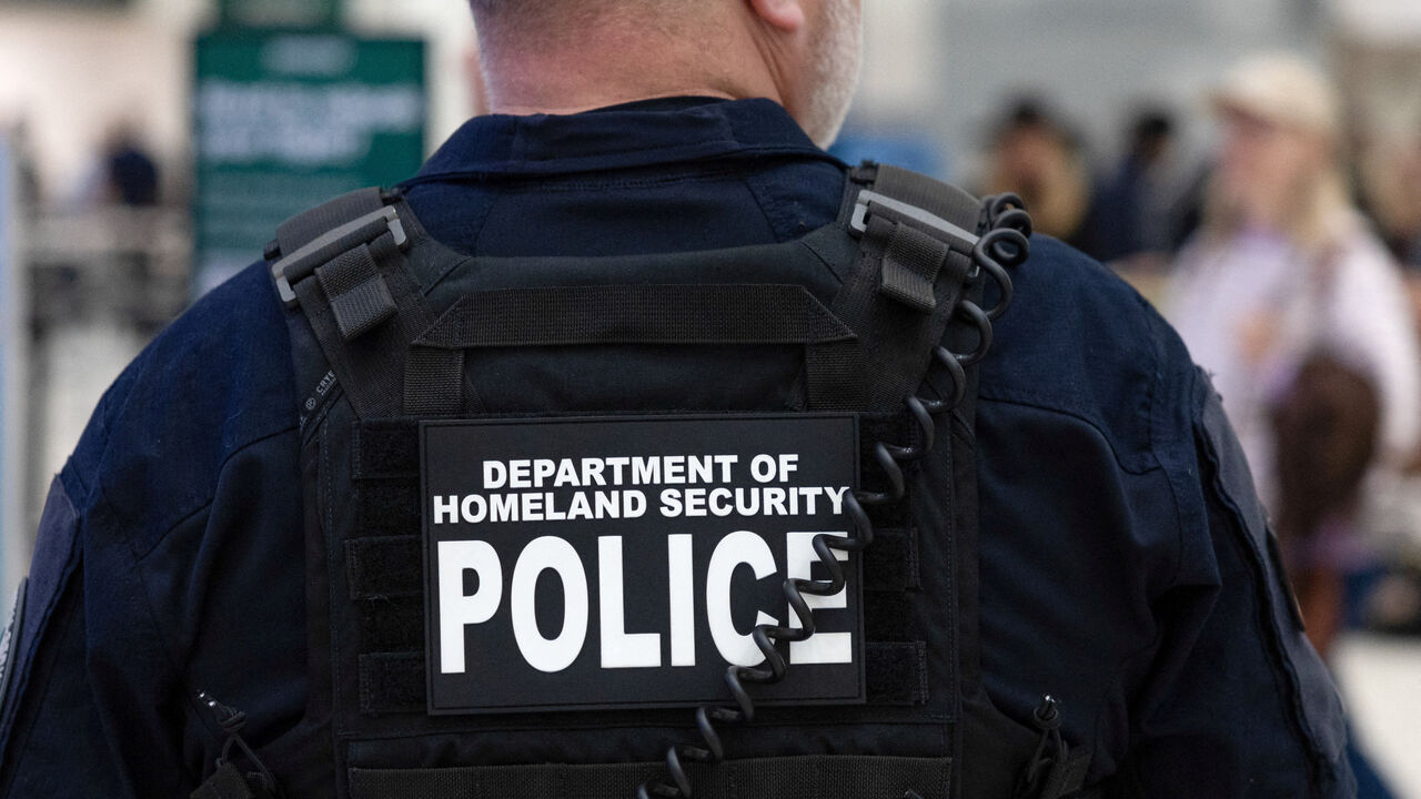 FILE PHOTO: A Department of Homeland Security officer directs passengers as they wait in long TSA lines at the George Bush Intercontinental Airport in Houston, Texas, U.S., March 25, 2026.    REUTERS/Antranik Tavitian/File Photo