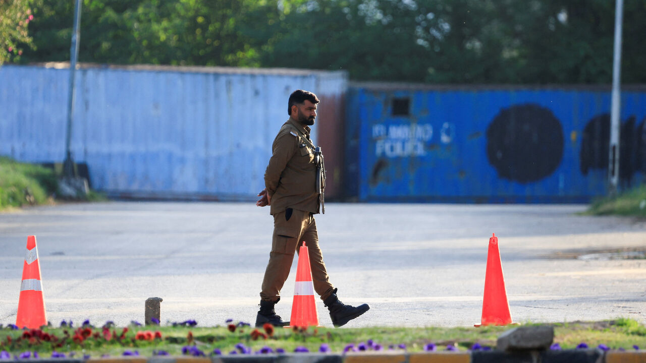 A police officer guards a road blocked with shipping containers, for security measures at D Chowk near the President's House as Pakistan prepares to host the United States and Iran for the second phase of peace talks in Islamabad, Pakistan, April 20, 2026. REUTERS/Akhtar Soomro