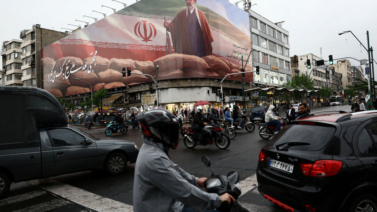 FILE PHOTO: People ride motorcycles near a billboard featuring an image of Iran's new Supreme Leader Mojtaba Khamenei, amid a ceasefire between U.S. and Iran, in Tehran, Iran, April 20, 2026. Majid Asgaripour/WANA (West Asia News Agency) via REUTERS/File Photo