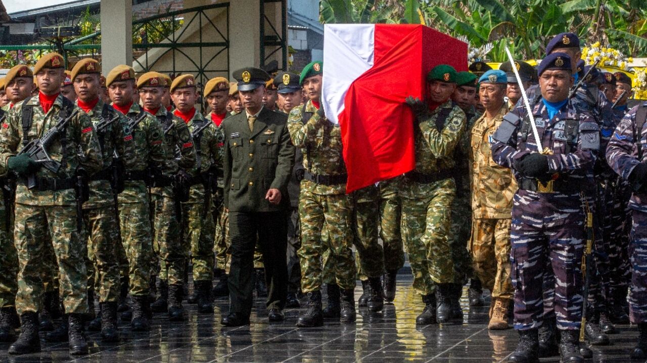 Military pallbearers carry the coffin of fallen compatriot and UN peacekeeper Farizal Rhomadhon during his funeral at the Giripeni Heroes' Cemetery in  Yogyakarta on April 5