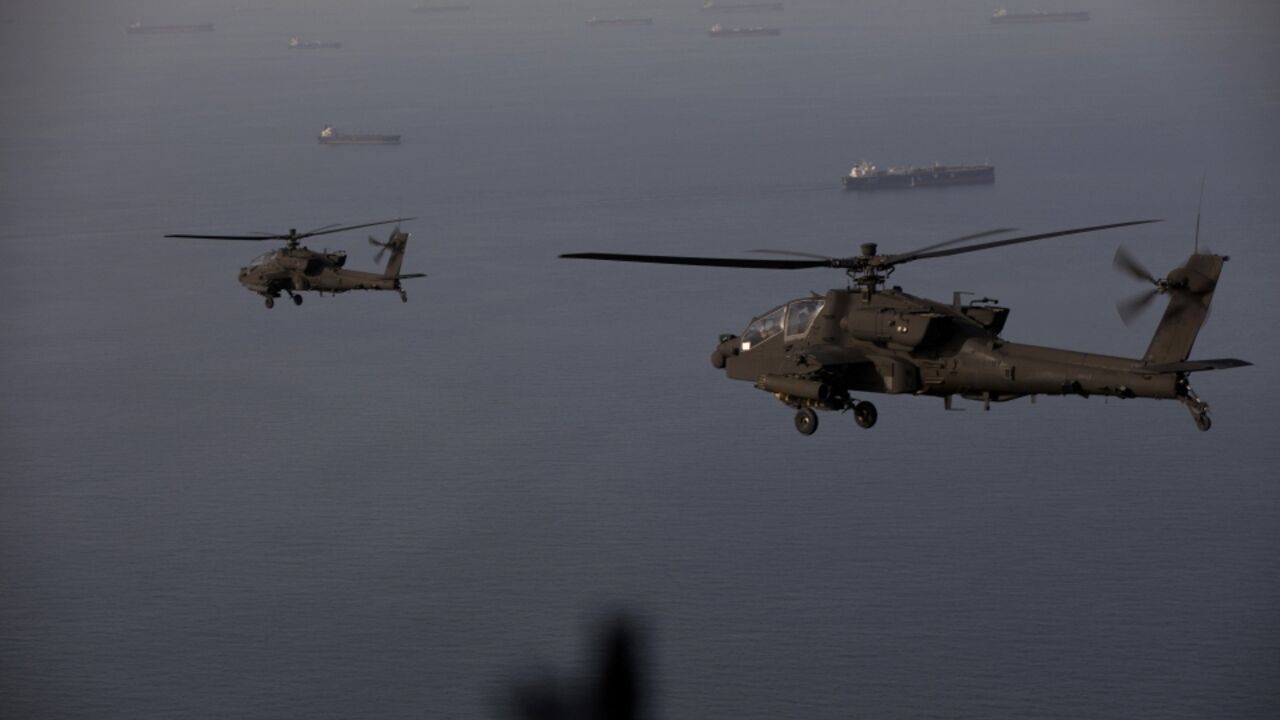 This handout photo released by US Central Command shows AH-64 Apaches flying above the Strait of Hormuz during a patrol on April 17, 2026