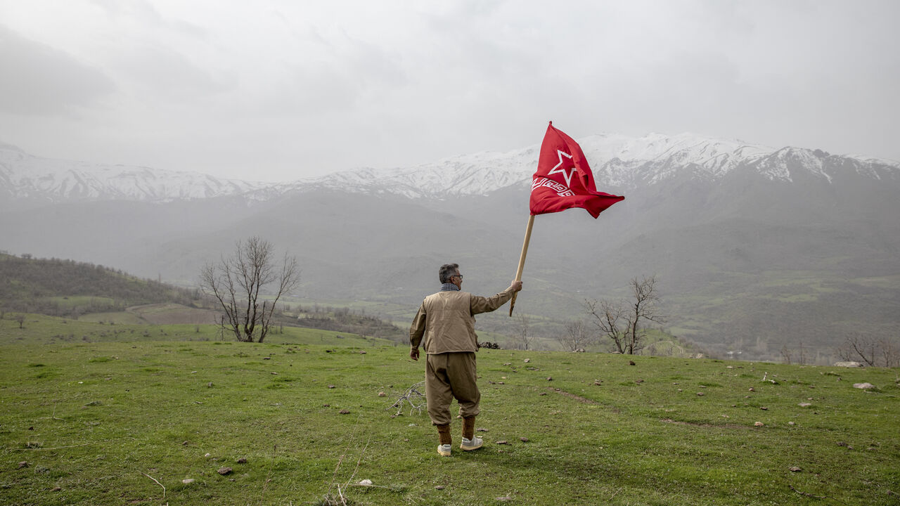 A armed Kurdish Peshmerga of the Komala party waves the Komala flag in a ceremony held in memory of Komala Martyrs' Day in Sidakan, Kurdistan Region of Iraq, on March 17, 2021.