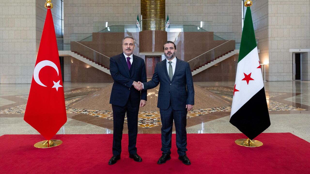 This handout photograph provided by the Turkish Foreign Ministry press service shows Turkish Foreign Minister Hakan Fidan (L) meeting with Syria's Foreign Minister Asaad al-Shaibani (R) in Damascus on Dec. 22, 2025. 