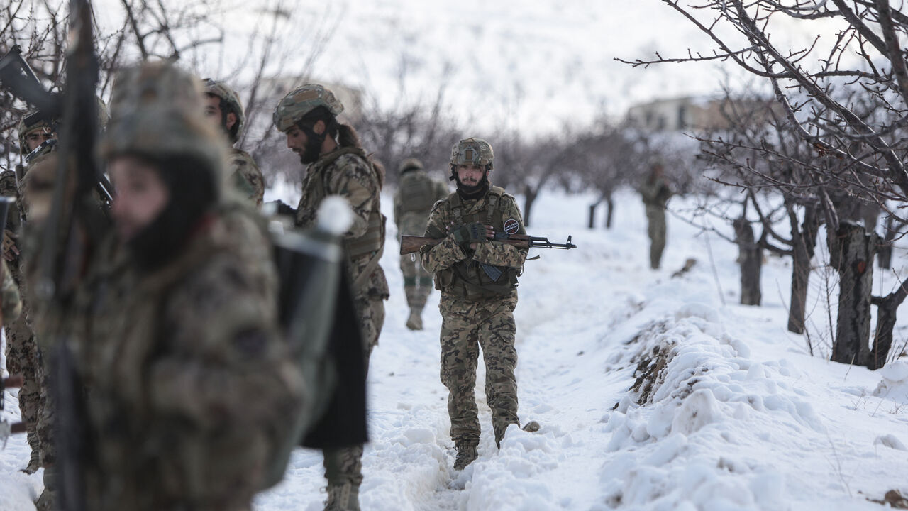Syrian soldiers stand in the snow in the country's mountainous Qalamoun region, near the border with Lebanon, during a patrol to secure the frontier and prevent smuggling operations on January 1, 2026. (Photo by Bakr ALkasem / AFP via Getty Images)
