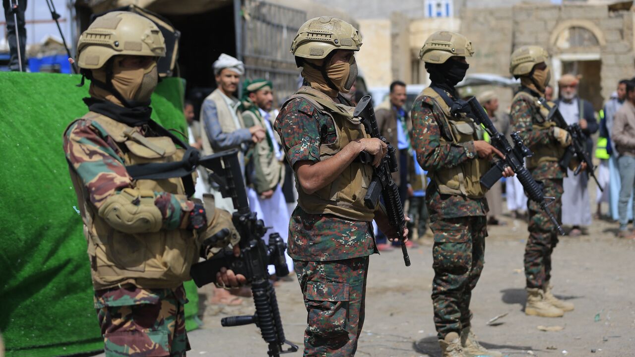 Members of Houthi security forces stand guard while supporters of Yemen's Houthi movement attend an event commemorating the ninth anniversary of the Saudi-led intervention in their country, in the capital, Sanaa, on March 26, 2026. 