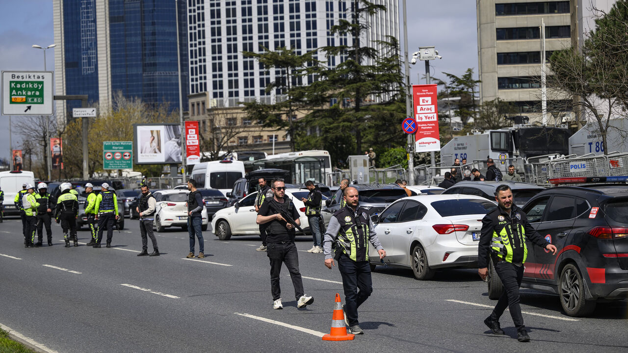 Police officials stand among traffic as they patrol near the Israeli Consulate following a shootout between gunmen and police, Istanbul, Turkey, April 7, 2026.