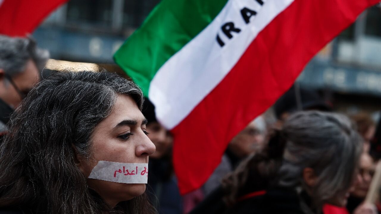 A demonstrator in Paris wears a sticker over her mouth with the words "no execution" prior to a silent march denouncing the Iranian government's deadly crackdown on anti-government protesters in the Islamic Republic
