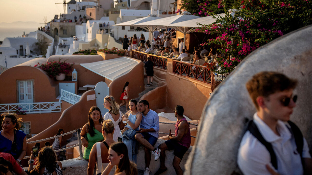 FILE PHOTO: Tourists wait to view Santorini’s famed sunset, on Santorini, Greece, July 25, 2024. REUTERS/Alkis Konstantinidis/File Photo