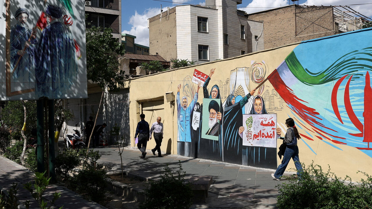 People walk on a street near a mural featuring an image of the late Supreme Leader of Iran, Ayatollah Ali Khamenei, in Tehran, Iran, May 18, 2026. Majid Asgaripour/WANA (West Asia News Agency) via REUTERS