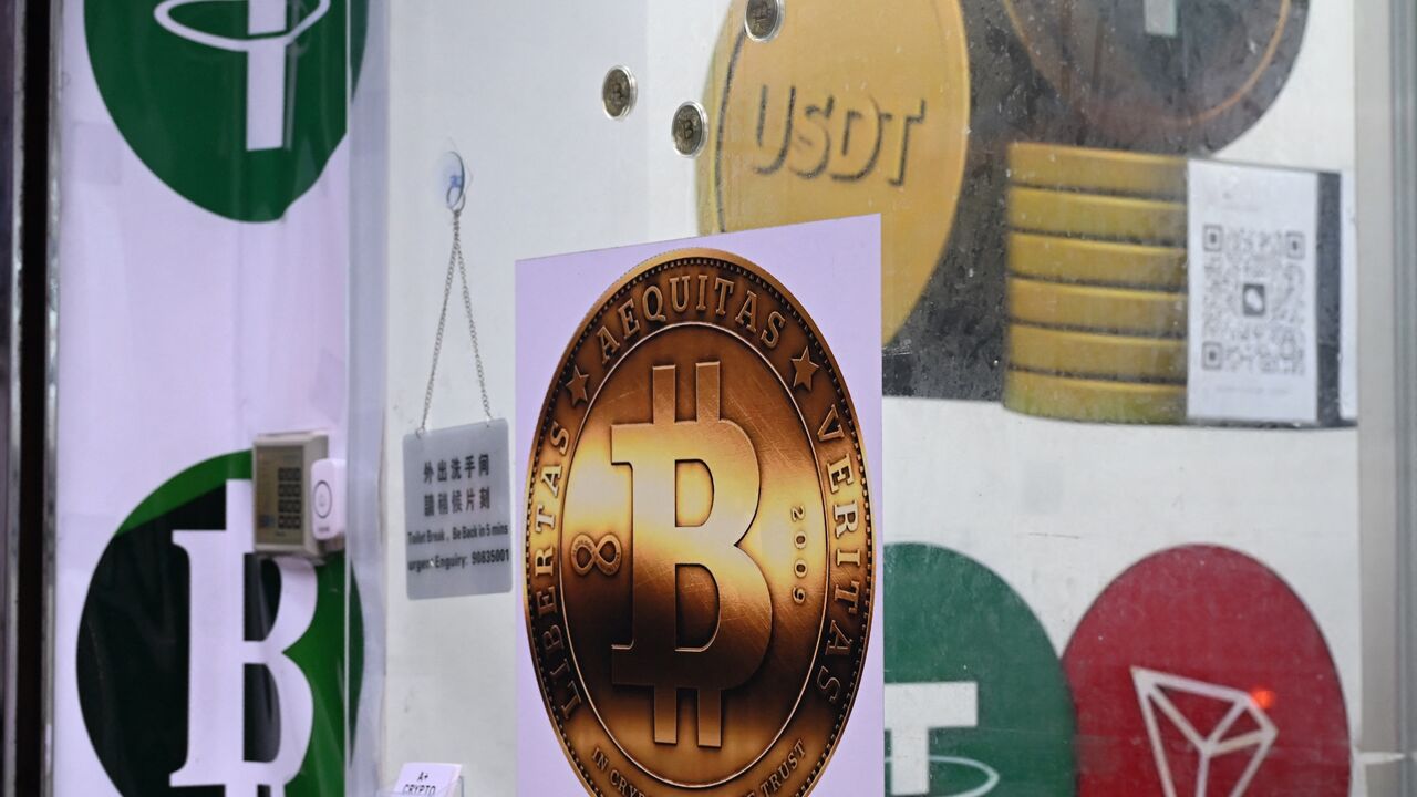 The symbols of bitcoin and the stablecoin Tether (USDT) are displayed at a cryptocurrency store in Hong Kong on July 29, 2025. 