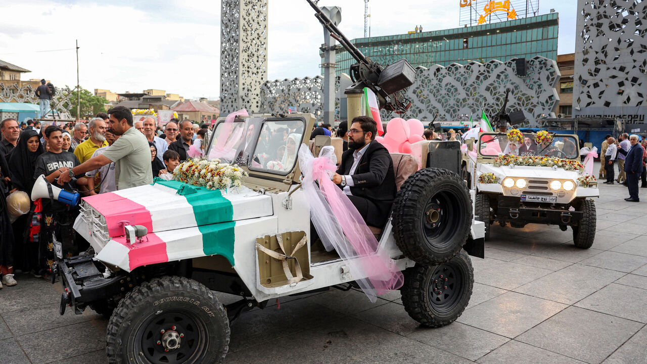 A bride and group couple rides in a military jeep arriving for a public mass wedding ceremony at Imam Hossein Square in Tehran on May 18, 2026. Iran said on May 18 that it had responded to a new US proposal aimed at ending the war, adding that diplomatic exchanges continue despite Iranian media reports describing Washington's demands as excessive. Washington and Tehran have been swapping proposals in an effort to end the conflict which the US and Israel launched on February 28, but they have held only a sin