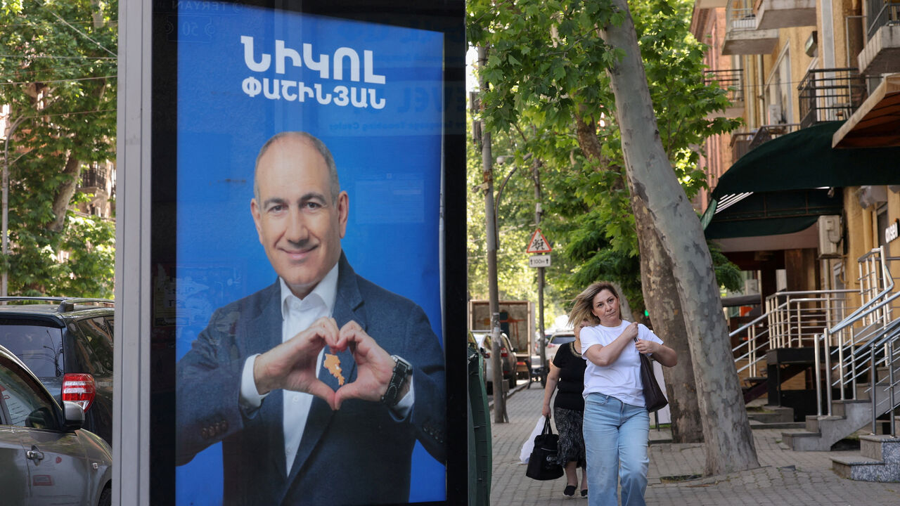 FILE PHOTO: People walk past campaign banners with portraits of Prime Minister Nikol Pashinyan of the Civil Contract party, ahead of the June 7 parliamentary election, in Yerevan, Armenia June 3, 2026. Hayk Baghdasaryan/Photolure via REUTERS/File Photo