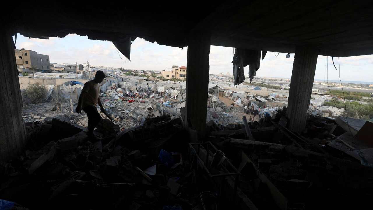 A Palestinian man inspects the site of an Israeli strike on a house whose residents were warned to evacuate before the attack, near a tent camp sheltering displaced people that was damaged in the strike, in Khan Younis in the southern Gaza Strip June 7, 2026. REUTERS/Ramadan Abed