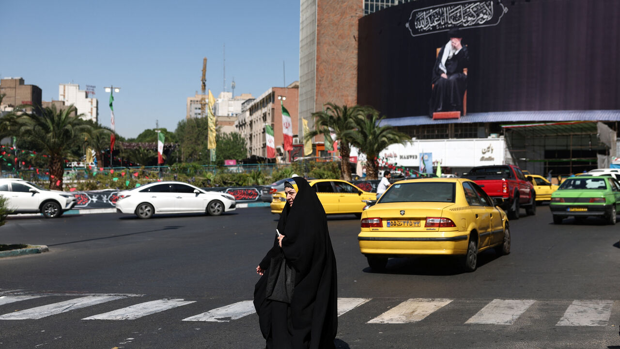 A woman walks past a billboard with a picture of the late Iran's Supreme Leader Ayatollah Ali Khamenei, after U.S. and Iranian officials said they had reached a deal to end their war and reopen the Strait of Hormuz, in Tehran, Iran, June 15, 2026. Majid Asgaripour/WANA (West Asia News Agency) via REUTERS