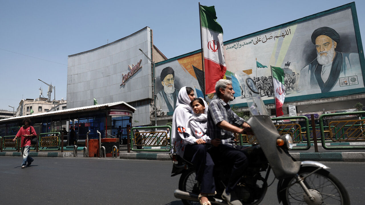 People ride past a mural depicting the late leader of the Islamic Revolution, Ayatollah Ruhollah Khomeini, and the late Iran's Supreme Leader Ayatollah Ali Khamenei, on a street in Tehran, Iran, June 9, 2026. Majid Asgaripour/WANA (West Asia News Agency) via REUTERS