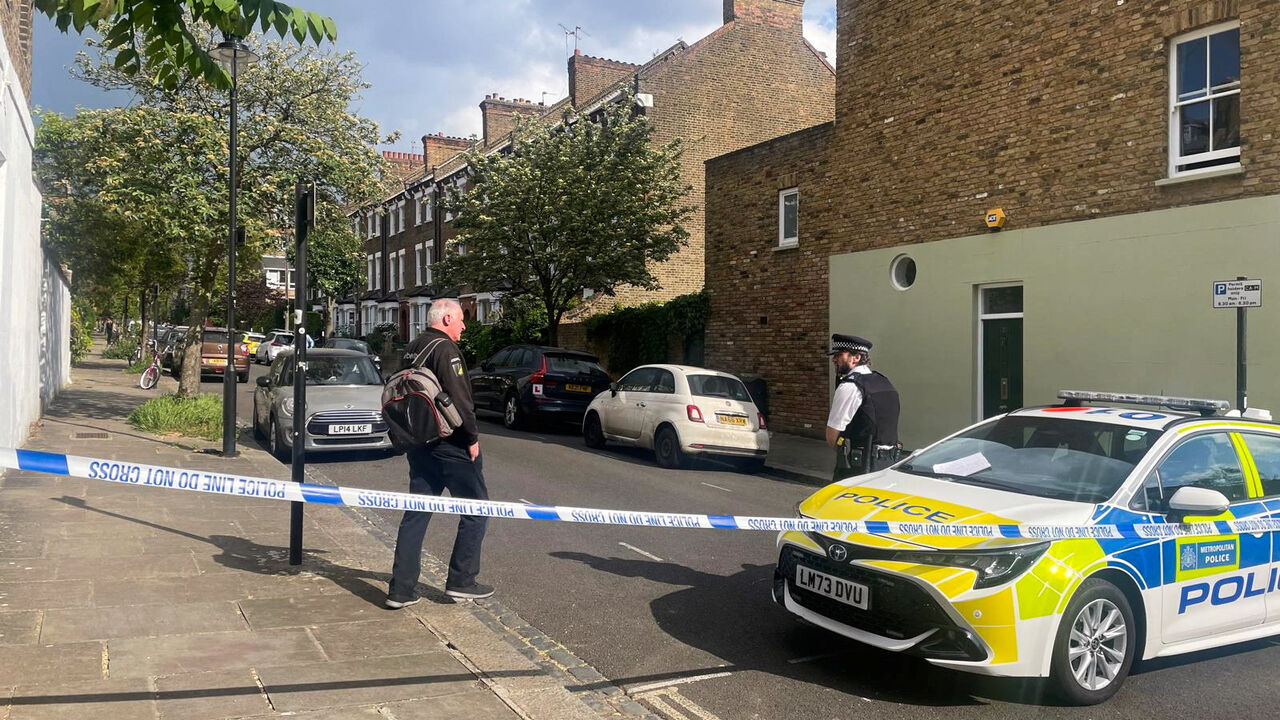 A person walks to a police officer at a cordoned off street, where a fire broke out at Britain's Prime Minister Keir Starmer's home in the early hours of Monday, in north London, Britain, May 12, 2025. REUTERS/Paul Sandle