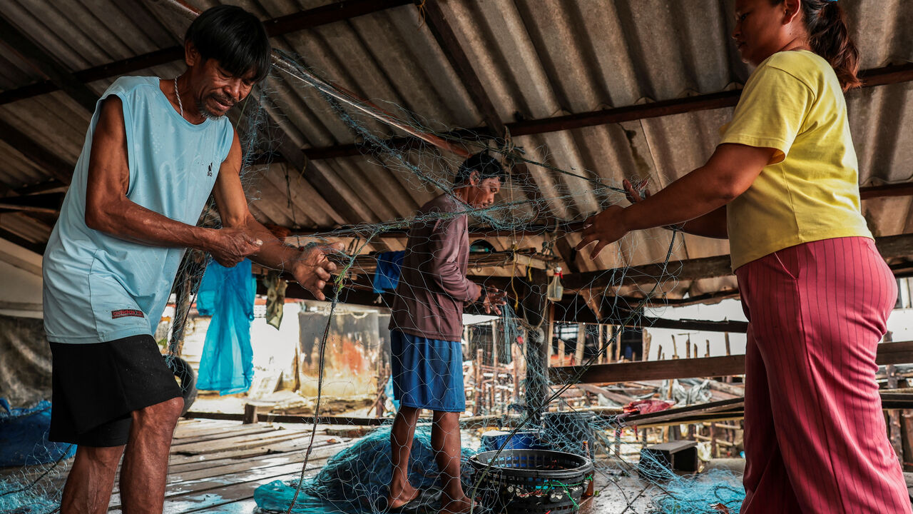 Chaiyaporn Arunrasamee, 50, a local fisherman, works on a fishing net with his relatives on Koh Haad Sai Dam Island, in Ranong province, Thailand, May 20, 2026. REUTERS/Chalinee Thirasupa