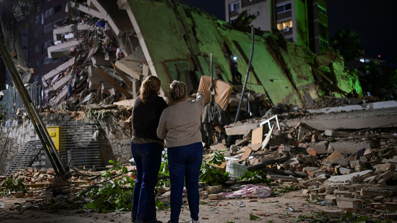 Fanny Nasri waits at the site of a collapsed building as emergency workers search for her son, Antonio Nasri, alongside Noemi Cordoba, who awaits news of her granddaughter, after an earthquake in Caracas, Venezuela, June 25, 2026. REUTERS/Gaby Oraa