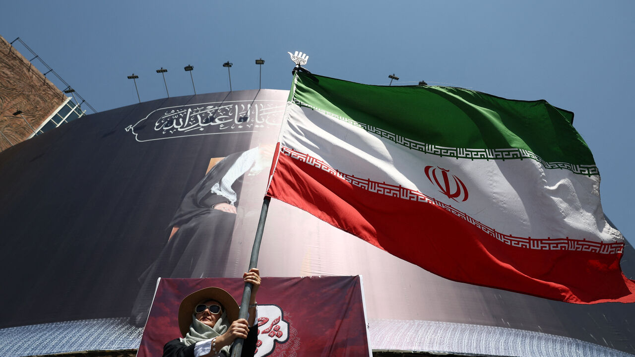 A woman holds an Iranian flag on a street in Tehran, Iran, June 30, 2026. Majid Asgaripour/WANA (West Asia News Agency) via REUTERS