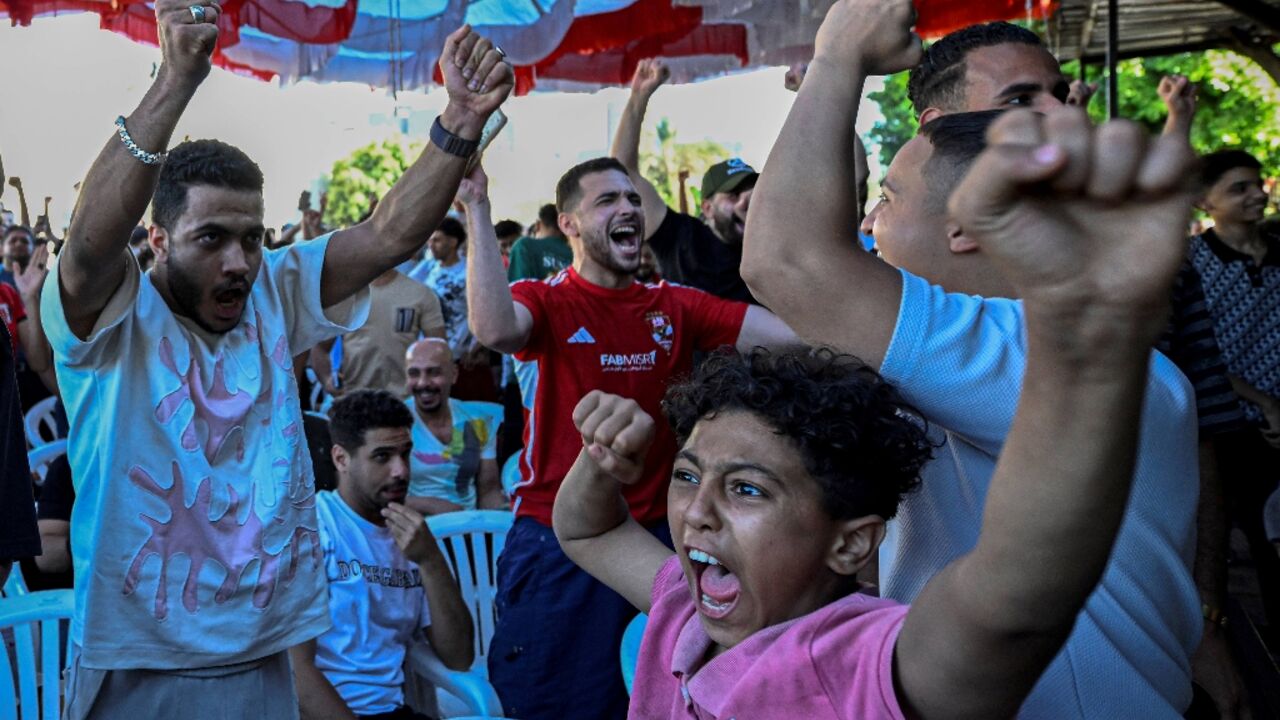 Egyptian football fans react as they watch their national team's 2026 World Cup Group G football match against Iran, at an outdoor cafe in the Sharabiya district of Cairo on June 27, 2026.