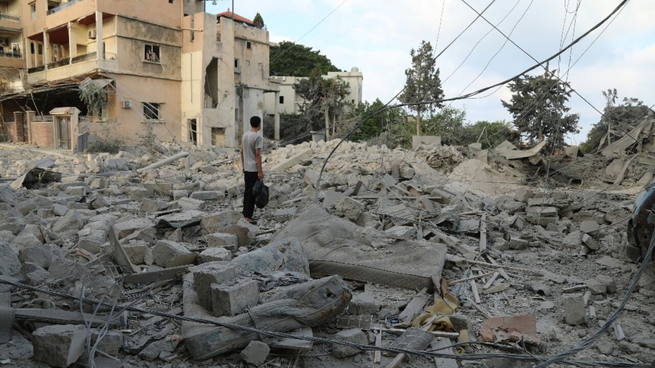 A man stands amid debris following Israeli airstrikes that hit the previous day, near the archaeological site of the Roman baths in the southern Lebanese city of Tyre