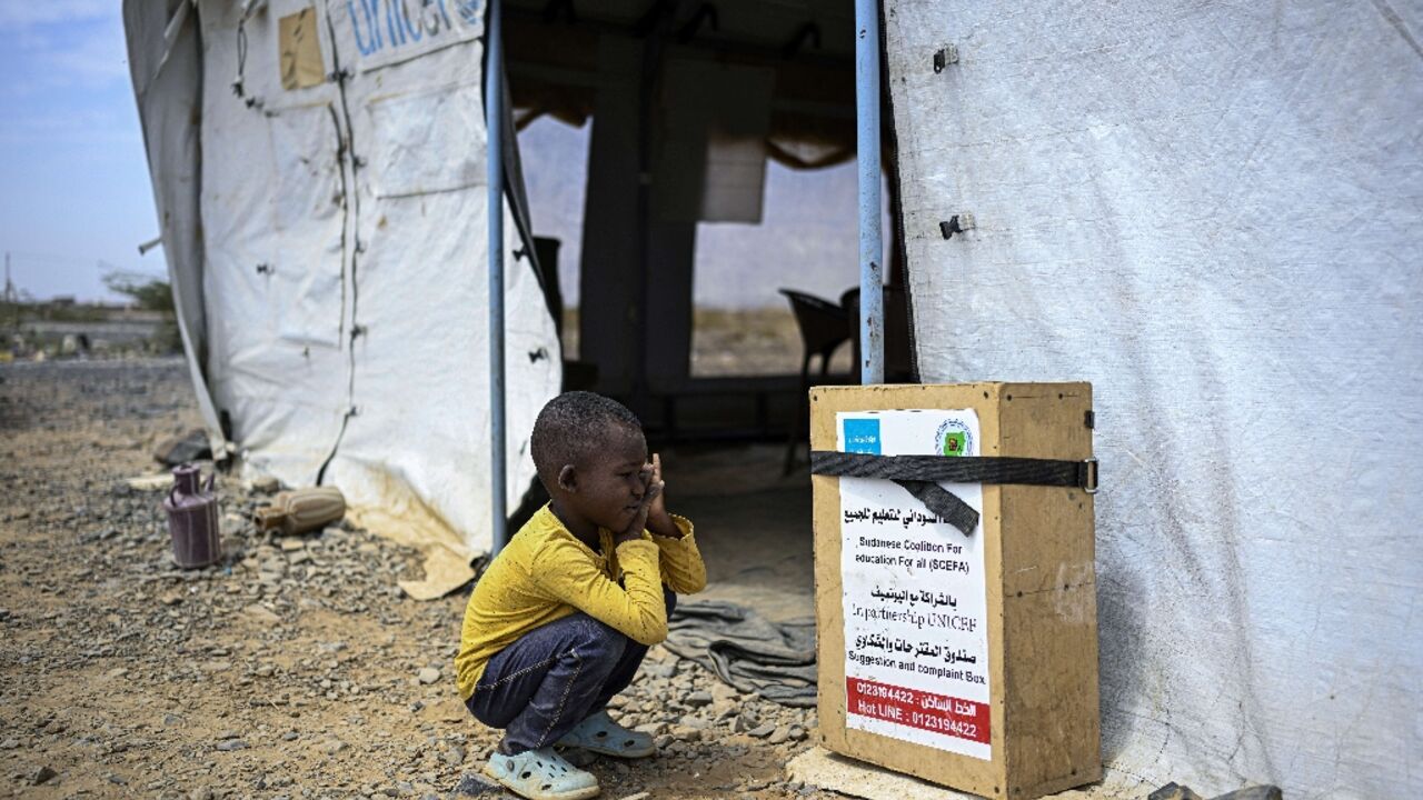 A displaced Sudanese student sitting outside a tent serving as a temporary classroom. The Middle East war is hitting UNICEF's supply chains