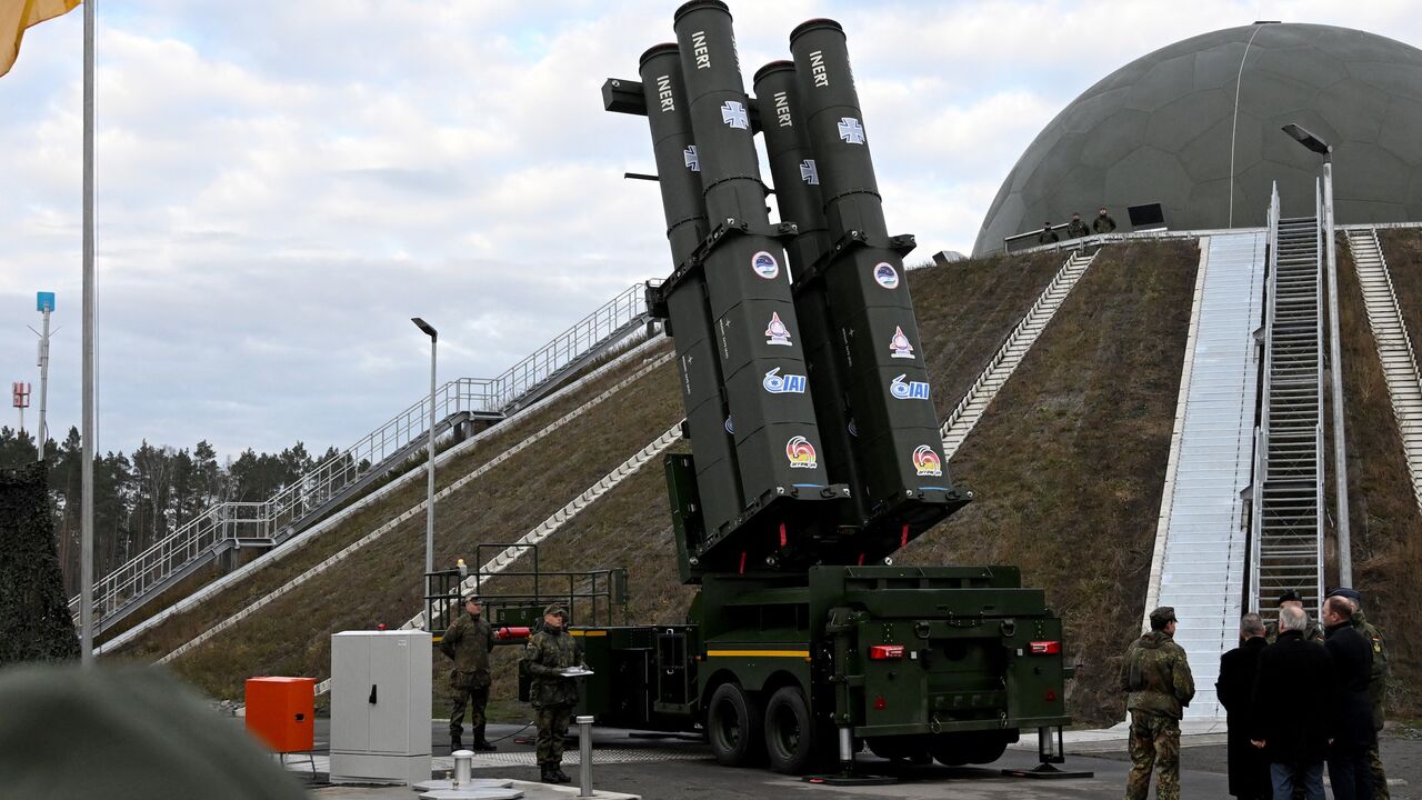 People stand in front of the Arrow 3 shield system during an event of the German Air Force to declare the Initial Operating Capability for the Arrow Weapon System for Germany at the Annaburger Heide Air Base in Schoenewalde / Holzdorf, eastern Germany, on Dec. 3, 2025.