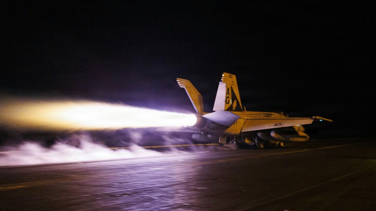 This US Navy handout photograph shows an F/A-18E Super Hornet launching from the flight deck of Nimitz-class aircraft carrier USS George H.W. Bush