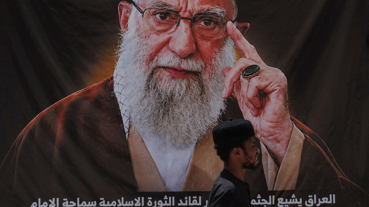 A man walks past a banner bearing a portrait of Iran's late Supreme Leader Ayatollah Ali Khamenei ahead of funeral processions in Najaf and Karbala, in Najaf, Iraq, July 7, 2026. REUTERS/Thaier Al-Sudani