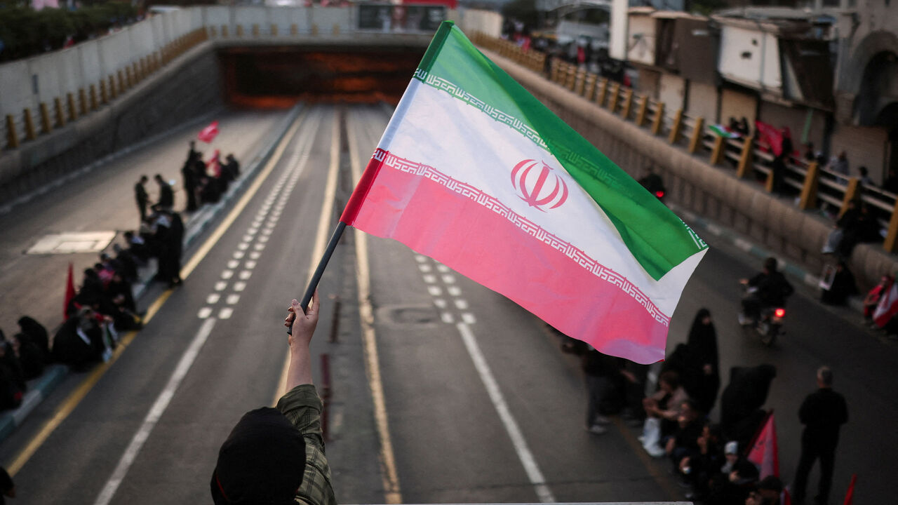 A mourner waves an Iranian flag on the day of the funeral procession for Iran's late Supreme Leader Ayatollah Ali Khamenei, who was killed on February 28 in Israeli and U.S. airstrikes, in Tehran, Iran, July 6, 2026.  REUTERS/Alkis Konstantinidis