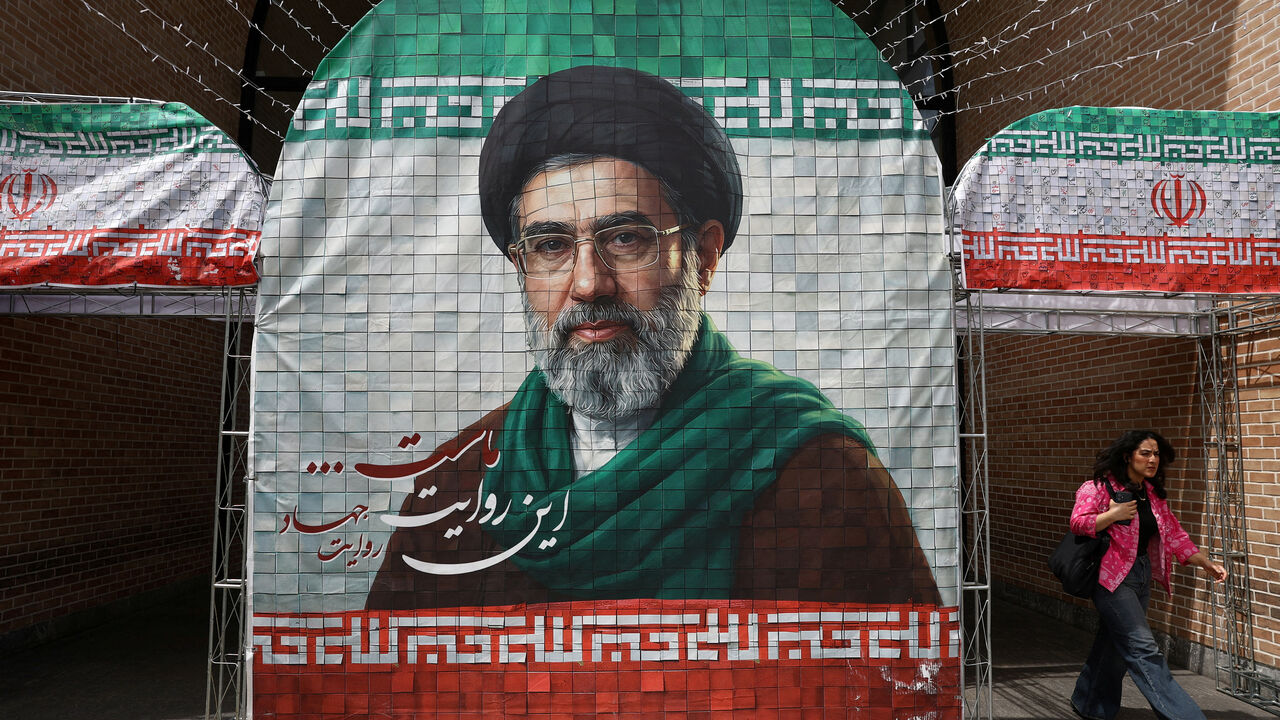 FILE PHOTO: A woman walks next to a banner with a picture of Iran's new Supreme Leader Mojtaba Khamenei in Tehran, Iran, May 8, 2026. Majid Asgaripour/WANA (West Asia News Agency) via REUTERS