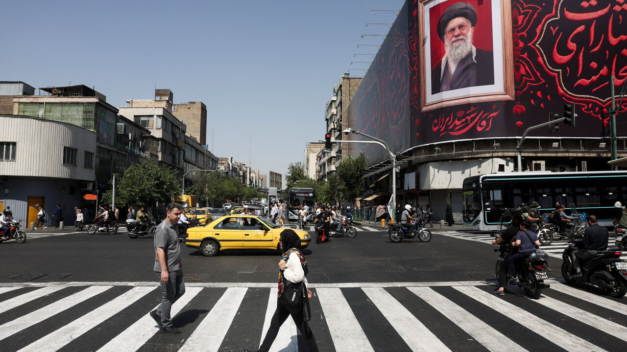 People walk past a billboard with an image of Iran's late Supreme Leader Ayatollah Ali Khamenei in Tehran, Iran, July 13, 2026. Majid Asgaripour/WANA (West Asia News Agency) via REUTERS