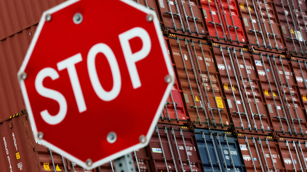 FILE PHOTO: A stop sign is pictured in front of shipping containers at the Port of Long Beach in Long Beach, California, U.S., July 11, 2025. REUTERS/Daniel Cole/File Photo