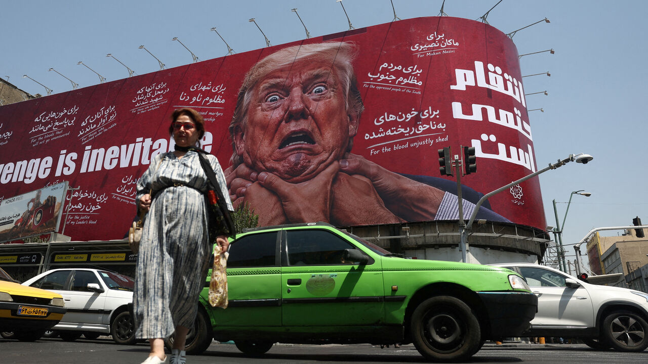 A woman walks near a billboard depicting U.S. President Donald Trump on a building in Tehran, Iran, July 27, 2026. Majid Asgaripour/WANA (West Asia News Agency) via REUTERS