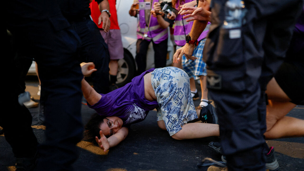Israeli security personnel hold an activist during a protest against violence committed by Israeli settlers against Palestinians in the occupied West Bank, in Tel Aviv, Israel, July 28, 2026. REUTERS/Amir Cohen